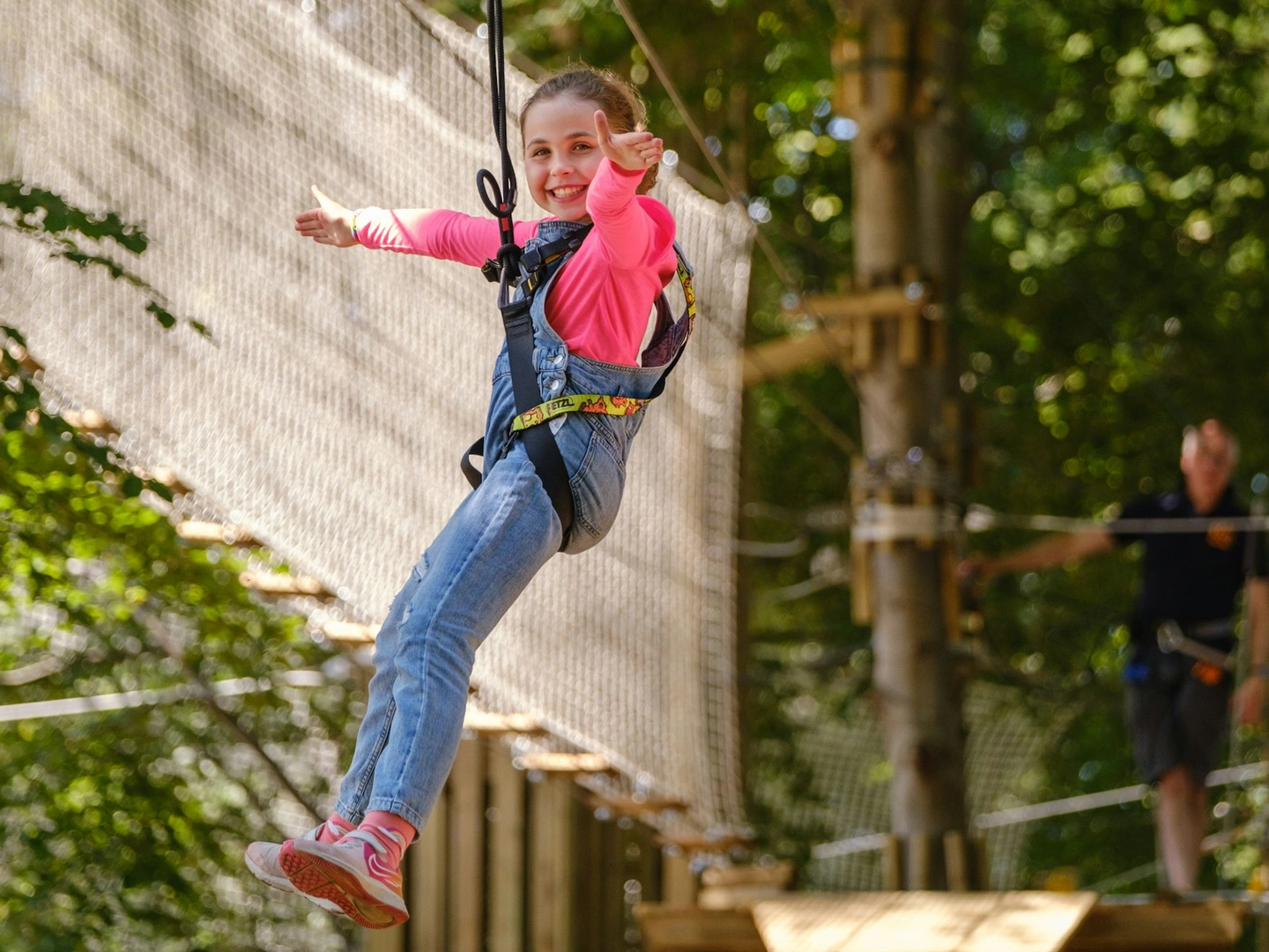 Young person smiles on a zipline.